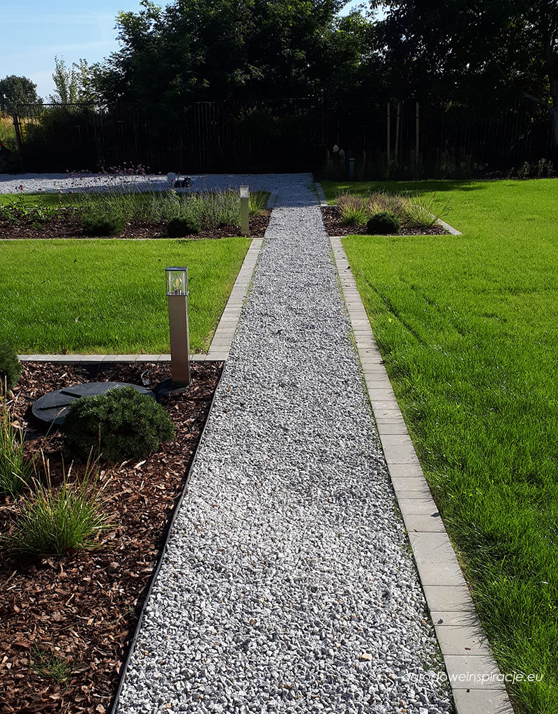 Ścieżka żwirowa z obrzeżem z kostki brukowej w nowoczesnym ogrodzie